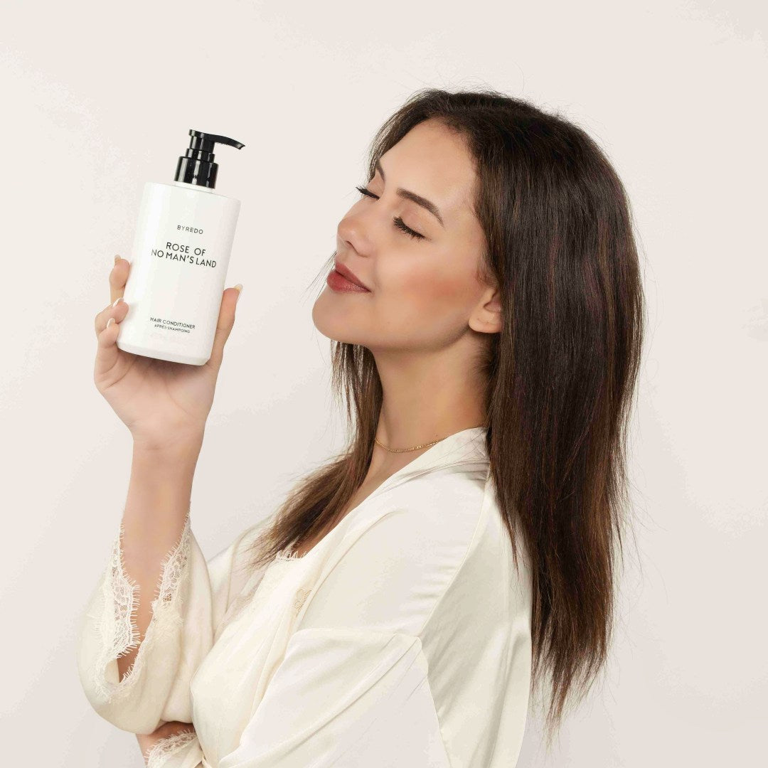 girl take byredo toiletries and Smile.